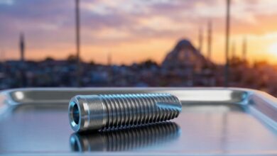 A photorealistic close-up of a sterile, titanium dental implant on a clean surface. In the heavily blurred background, the Istanbul, Turkey skyline is visible through a window during a warm sunset, representing dental tourism.