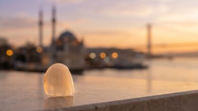 A close-up of a perfect dental veneer with the sunlit, blurred skyline of Istanbul, Turkey in the background, symbolizing a dental tourism and travel package.