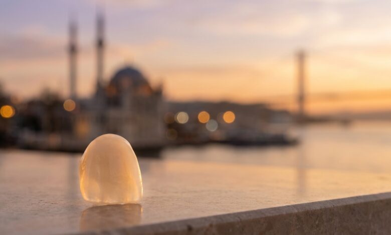 A close-up of a perfect dental veneer with the sunlit, blurred skyline of Istanbul, Turkey in the background, symbolizing a dental tourism and travel package.