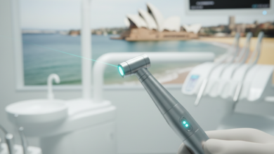 A photorealistic image showing a modern dental laser handpiece with a subtle light beam, held in a clean, high-tech dental clinic environment. The background features a softly blurred, iconic Australian landmark or a distinctive coastal view, subtly suggesting the location. The image emphasizes precision, innovation, and advanced dental technology.