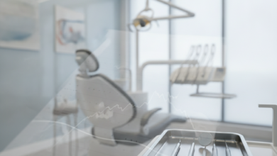 A photorealistic image showing a clean, modern dental clinic. In the foreground, a blurred abstract document symbolizes dental insurance and financial paperwork. In the mid-ground, sterile dental instruments are subtly visible on a tray, with a soft-focus dental chair and professional clinic background, illustrating the financial aspects of dental treatment.
