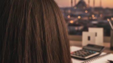 A photorealistic image focusing on the back of a head with healthy, dark hair in the foreground. Blurred in the mid-ground are abstract shapes suggesting financial planning tools like a calculator and notepad. In the heavily blurred background, a warm-lit Istanbul cityscape with domes and minarets is visible, representing medical tourism.